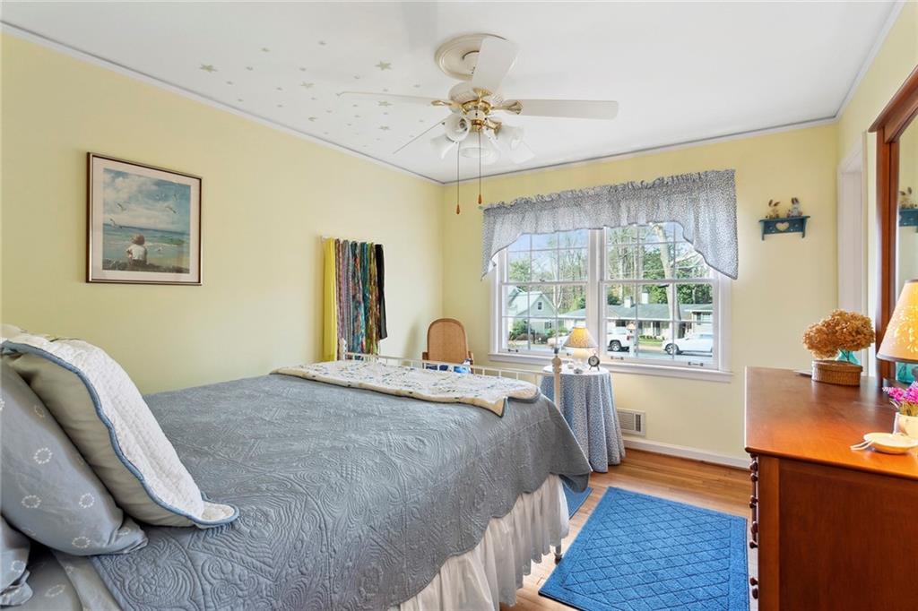 Bedroom with ornamental molding, light wood-type flooring, and ceiling fan Bedroom with ornamental molding, light wood-type flooring, and ceiling fan