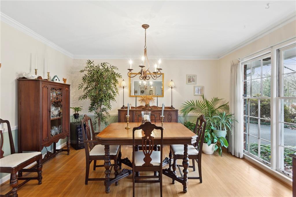 Dining space with crown molding, a chandelier, and light hardwood / wood-style floors Dining space with crown molding, a chandelier, and light hardwood / wood-style floors