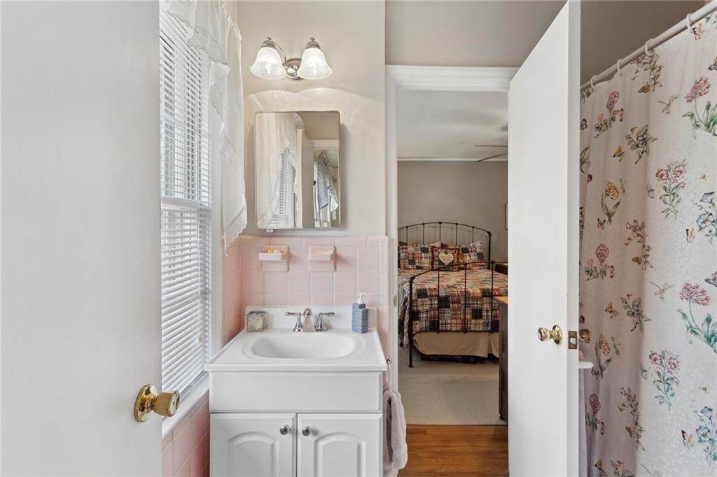 Bathroom featuring tile walls, hardwood / wood-style floors, and oversized vanity Bathroom featuring tile walls, hardwood / wood-style floors, and oversized vanity