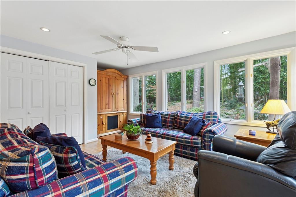 Living room featuring light hardwood / wood-style floors, a wealth of natural light, and ceiling fan Living room featuring light hardwood / wood-style floors, a wealth of natural light, and ceiling fan