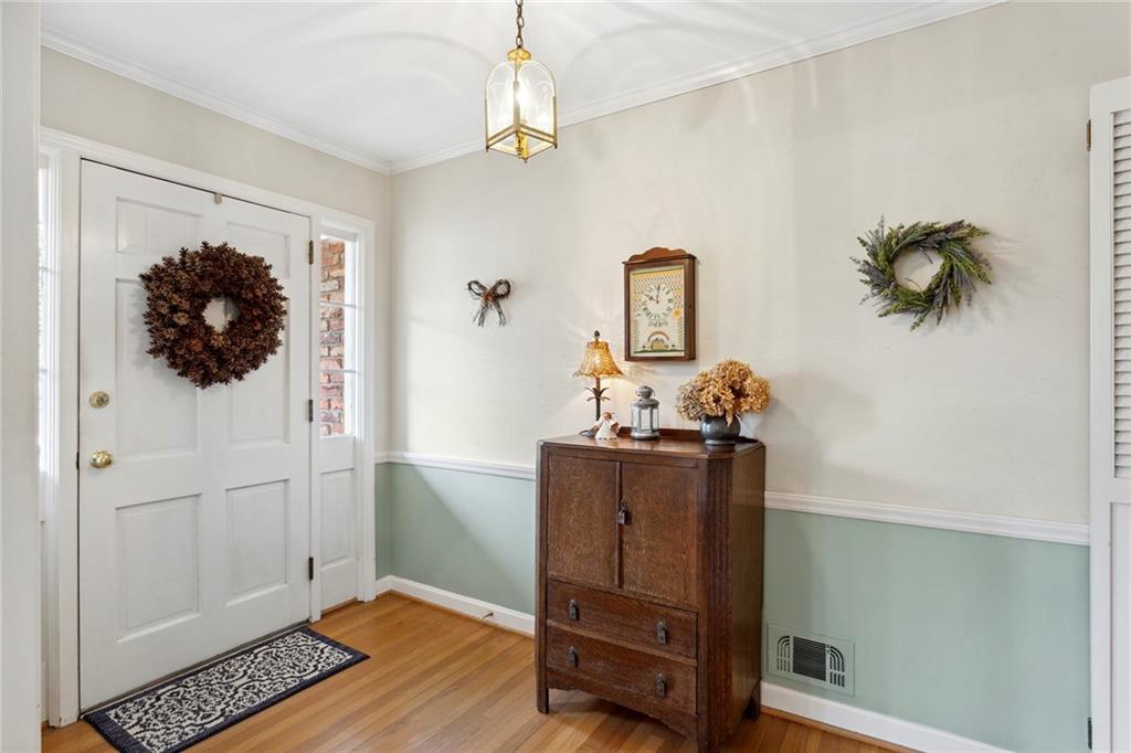 Foyer entrance with light hardwood / wood-style flooring and crown molding Foyer entrance with light hardwood / wood-style flooring and crown molding