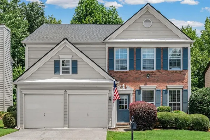 Two-story residence featuring a brick facade with light gray siding accents