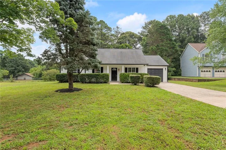 White exterior home with dark shutters and a dark garage door