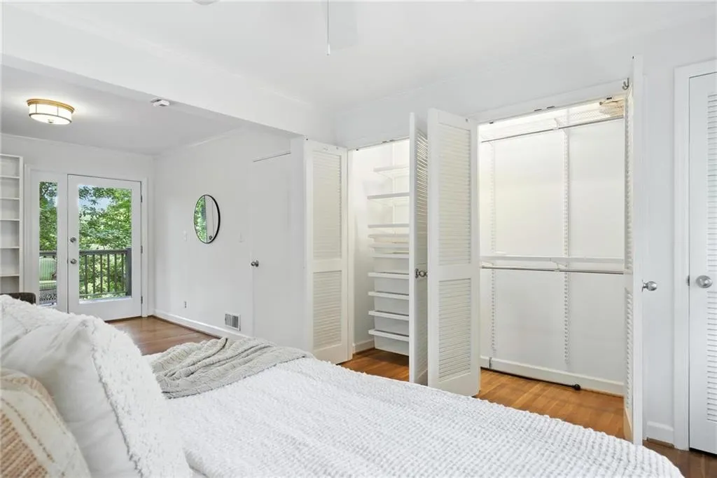 Bedroom featuring access to outside, ornamental molding, and wood finished floors