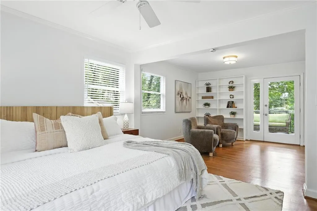 Bedroom with multiple windows, access to exterior, ornamental molding, wood finished floors, and a ceiling fan