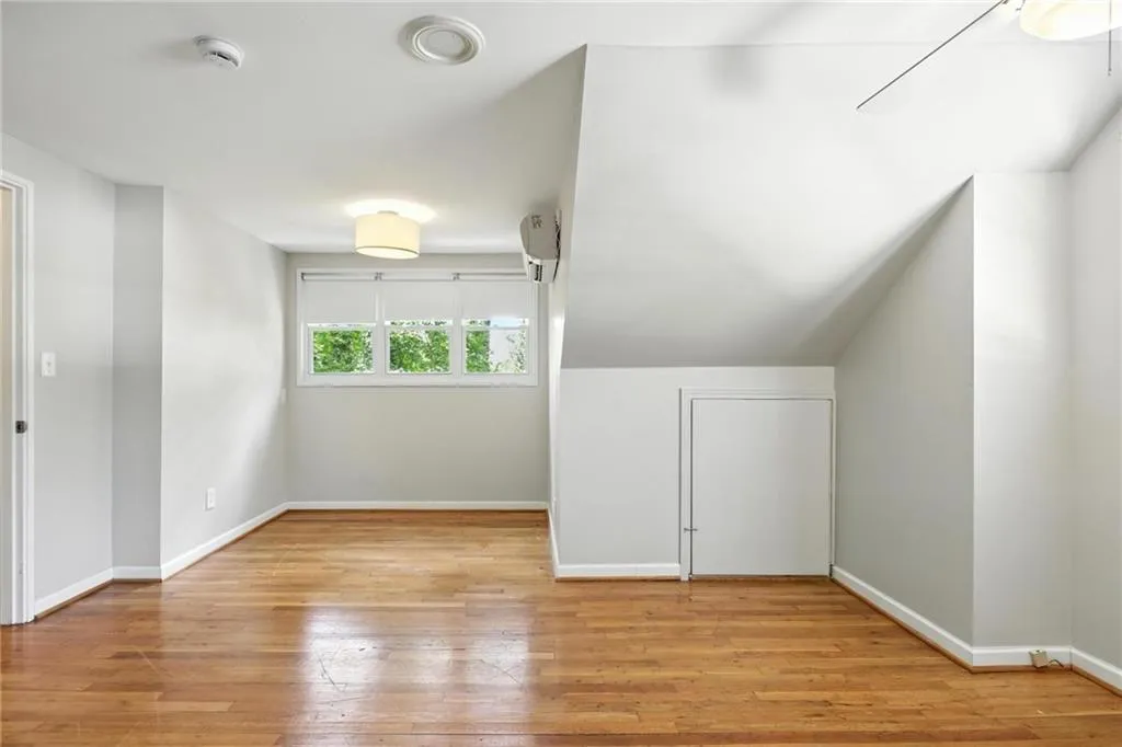 Bonus room featuring baseboards and wood-type flooring