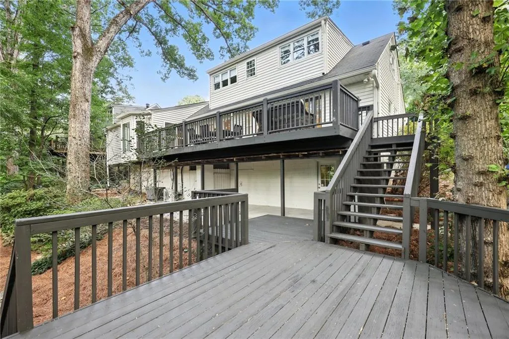 Deck featuring an attached garage and stairway