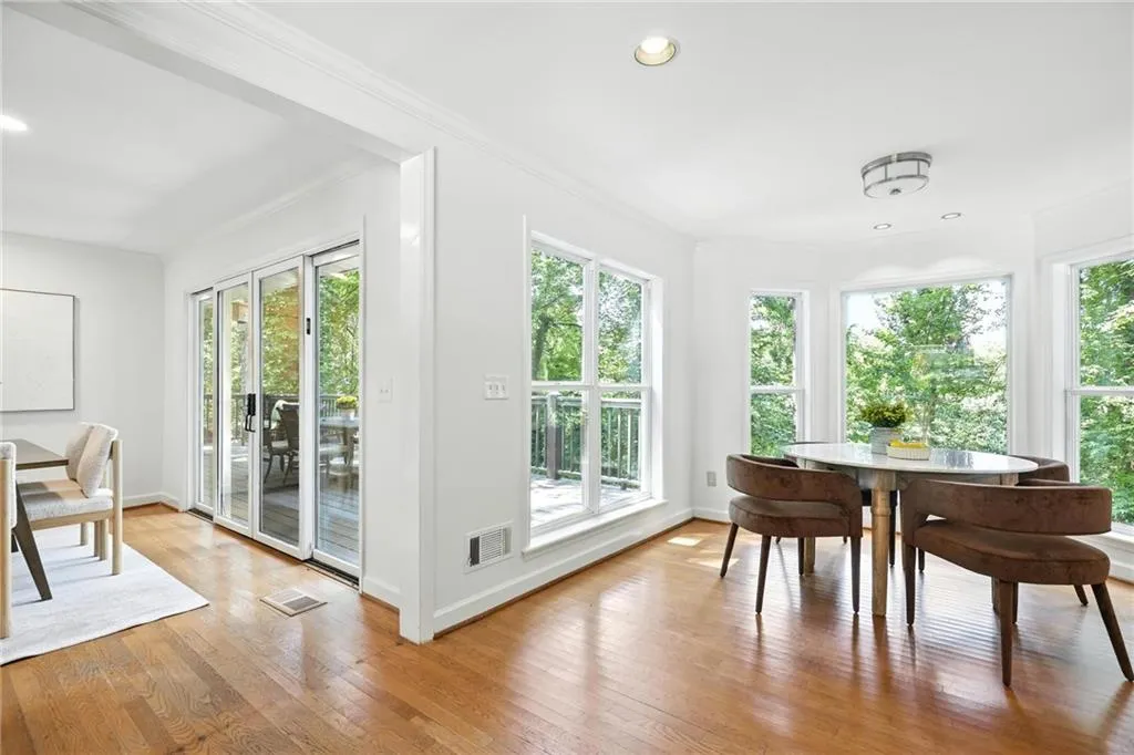 Dining space featuring healthy amount of natural light, hardwood / wood-style floors, crown molding, and recessed lighting