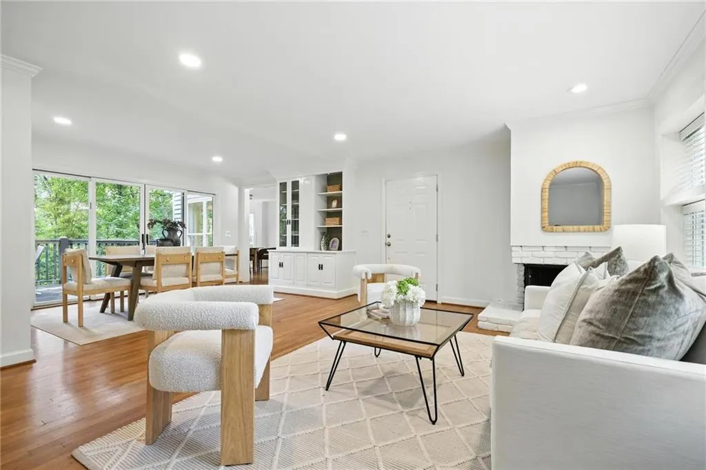 Living room featuring crown molding, light wood-style flooring, recessed lighting, and a fireplace