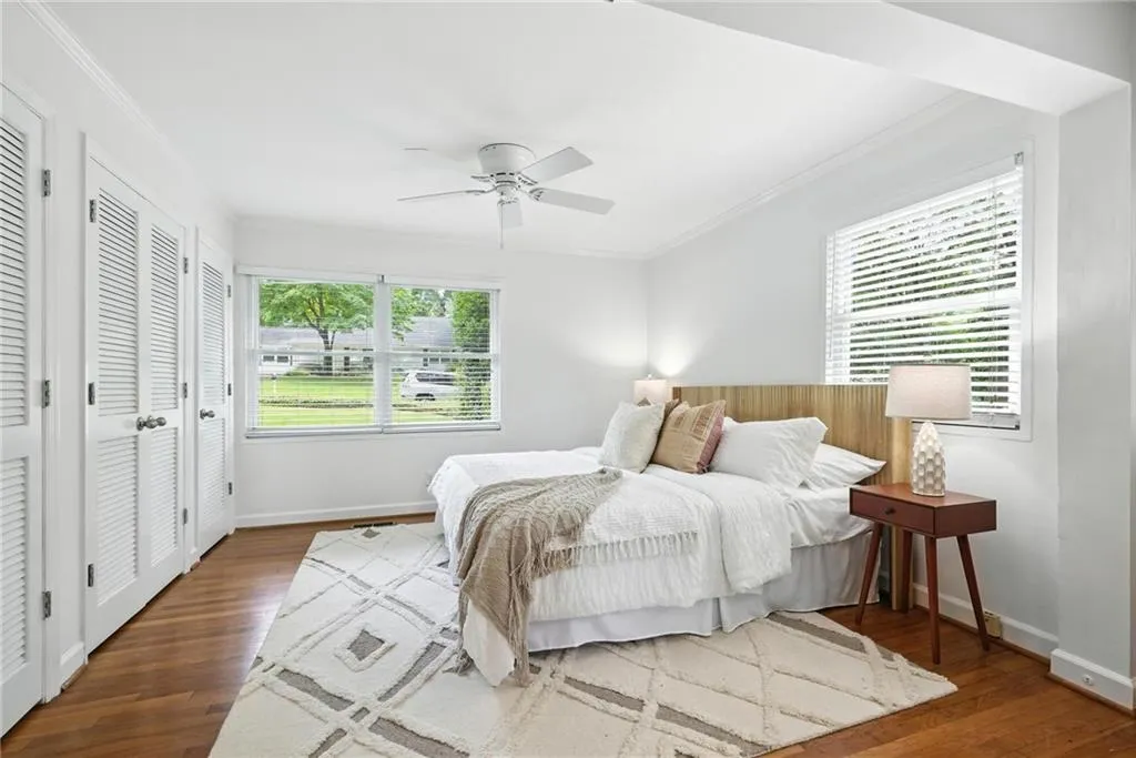 Bedroom featuring wood finished floors, crown molding, and ceiling fan
