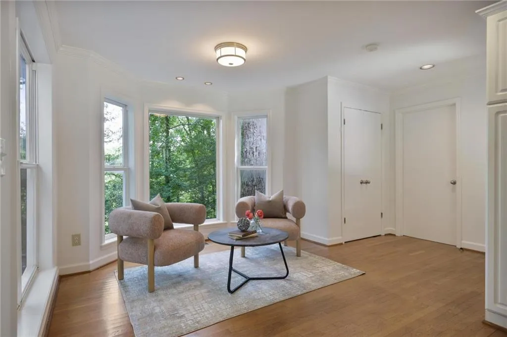 Living area with ornamental molding, light wood-type flooring, and recessed lighting