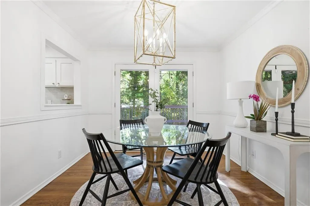 Dining space featuring dark wood-style floors, crown molding, and a chandelier