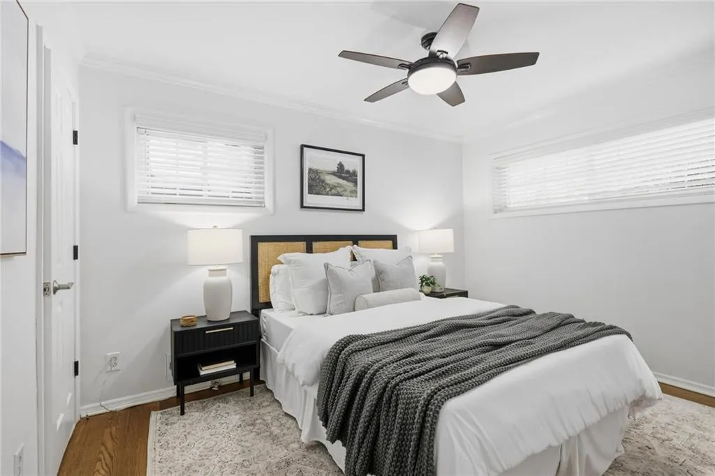 Bedroom featuring wood finished floors, ornamental molding, and ceiling fan