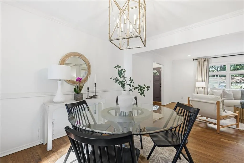 Dining room featuring ornamental molding, wood finished floors, and a chandelier