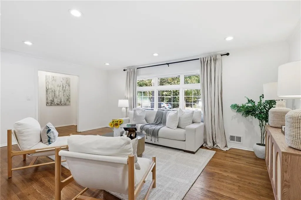Living room featuring wood finished floors, recessed lighting, and ornamental molding