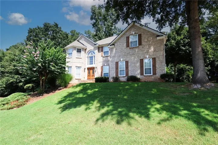 Brick exterior with an arched window, decorative shutters, and a prominent front entrance