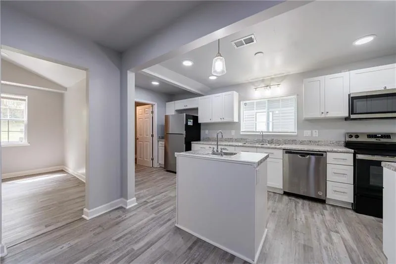 Kitchen with stainless steel appliances, light wood finished floors, and a sink