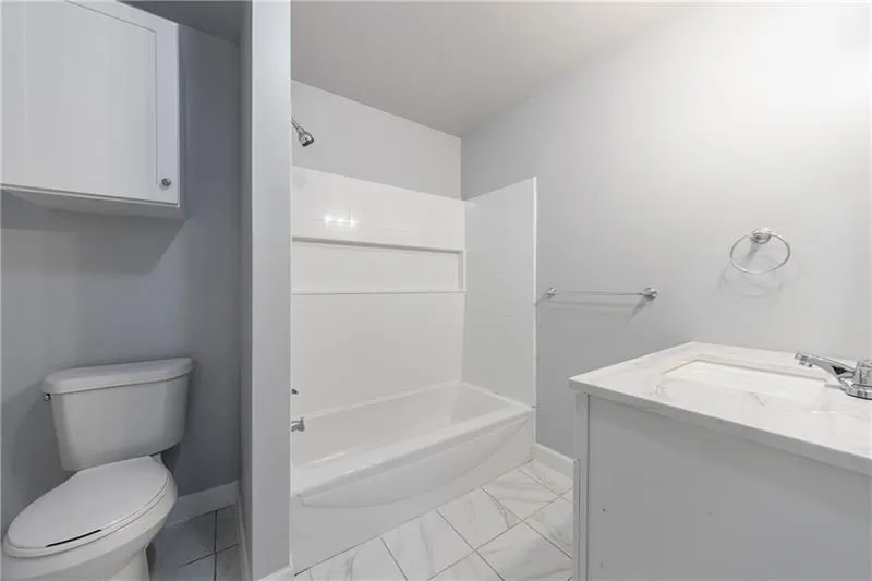 Full bathroom featuring baseboards, toilet, bathing tub / shower combination, vanity, and marble finish floor