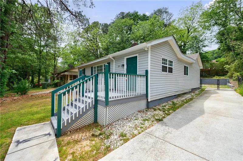 View of front of house featuring a chimney, a deck, and a gate