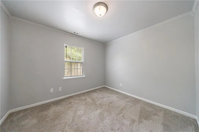 Bedroom featuring visible vents, baseboards, ornamental molding, and carpet flooring