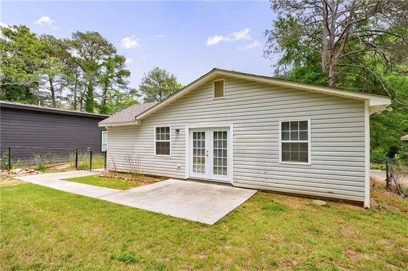 Back of property with fence, french doors, a yard, and a patio area