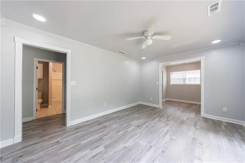 Spare room featuring visible vents, ceiling fan, and ornamental molding