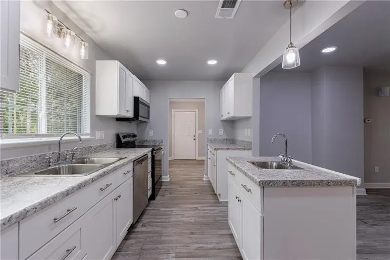 Kitchen with stainless steel appliances, light wood finished floors, and a sink