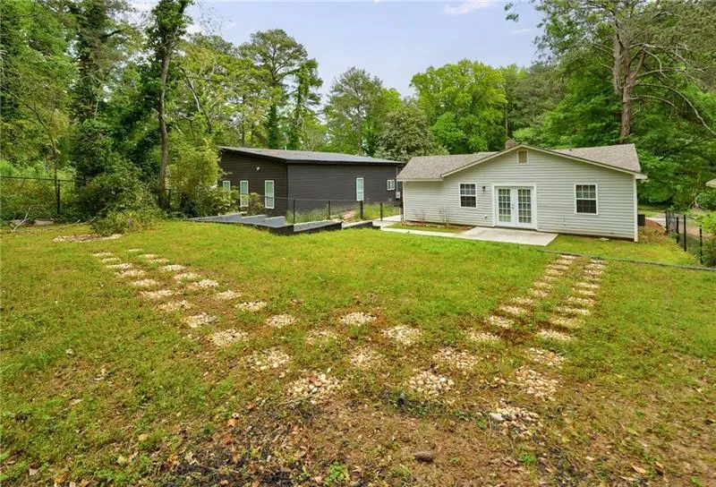 Back of house with a lawn, a fenced backyard, french doors, and a patio area