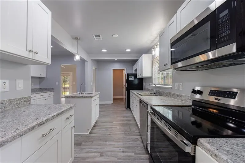 Kitchen featuring stainless steel appliances, light wood-style flooring, and a sink