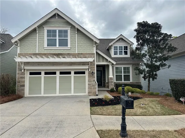 Craftsman-style house featuring stone siding, an attached garage, concrete driveway, and a shingled roof