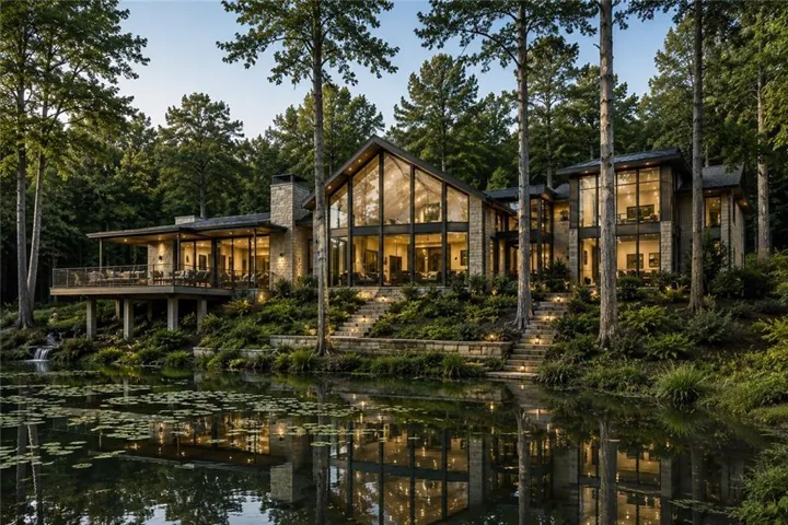 Stone exterior with expansive multi-story windows and a large outdoor deck