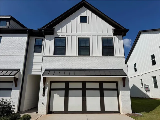 White brick and board and batten exterior with dark trim