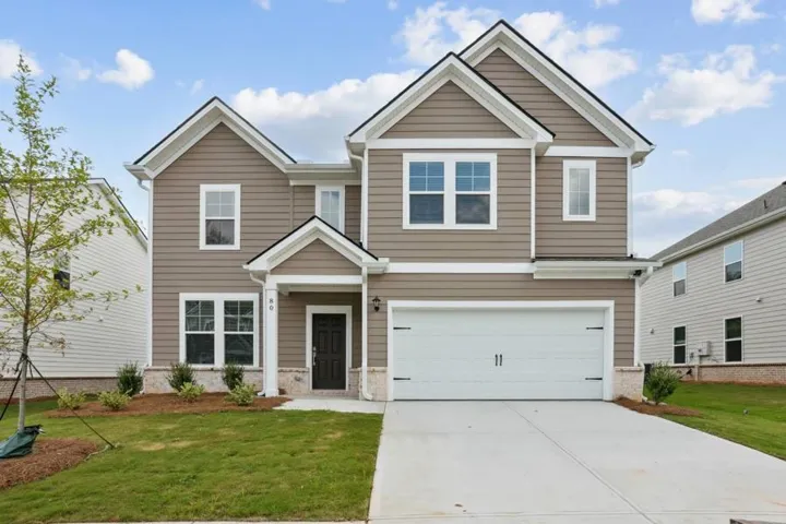 View of front of home featuring concrete driveway, a front lawn, and brick siding