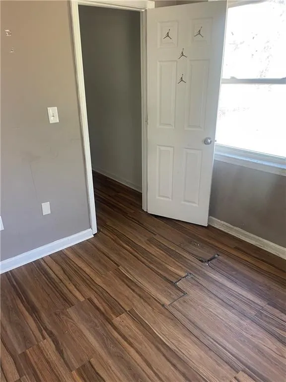 Empty room featuring dark hardwood / wood-style floors