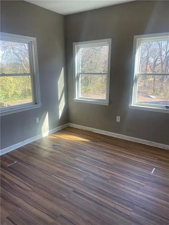 Unfurnished room featuring dark hardwood / wood-style floors