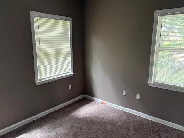 Carpeted empty room featuring baseboards