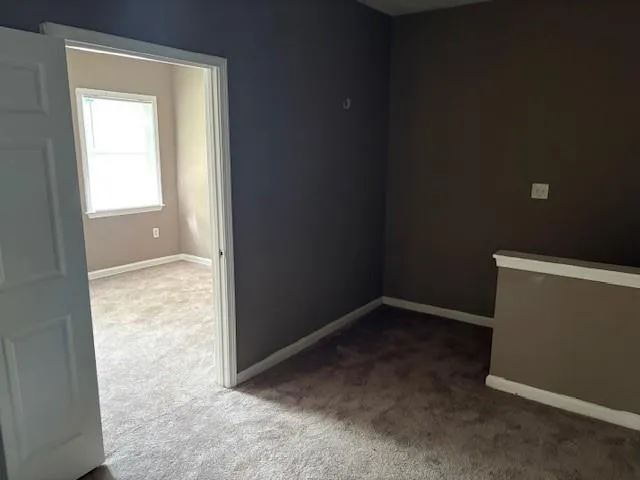 Carpeted spare room with baseboards