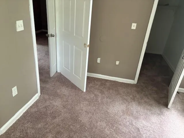 Unfurnished bedroom with carpet floors and a spacious closet