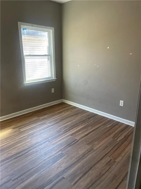 Empty room featuring dark hardwood / wood-style floors