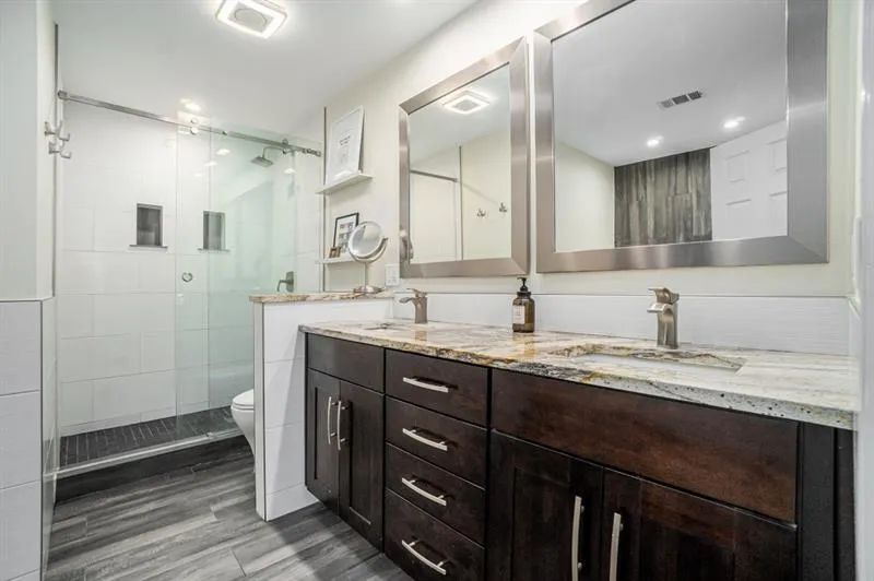 Spa-Like Ensuite Bath with Dual Vanities, a Large Soaking Tub, and a Separate Glass Shower. Spa-Like Ensuite Bath with Dual Vanities, a Large Soaking Tub, and a Separate Glass Shower.