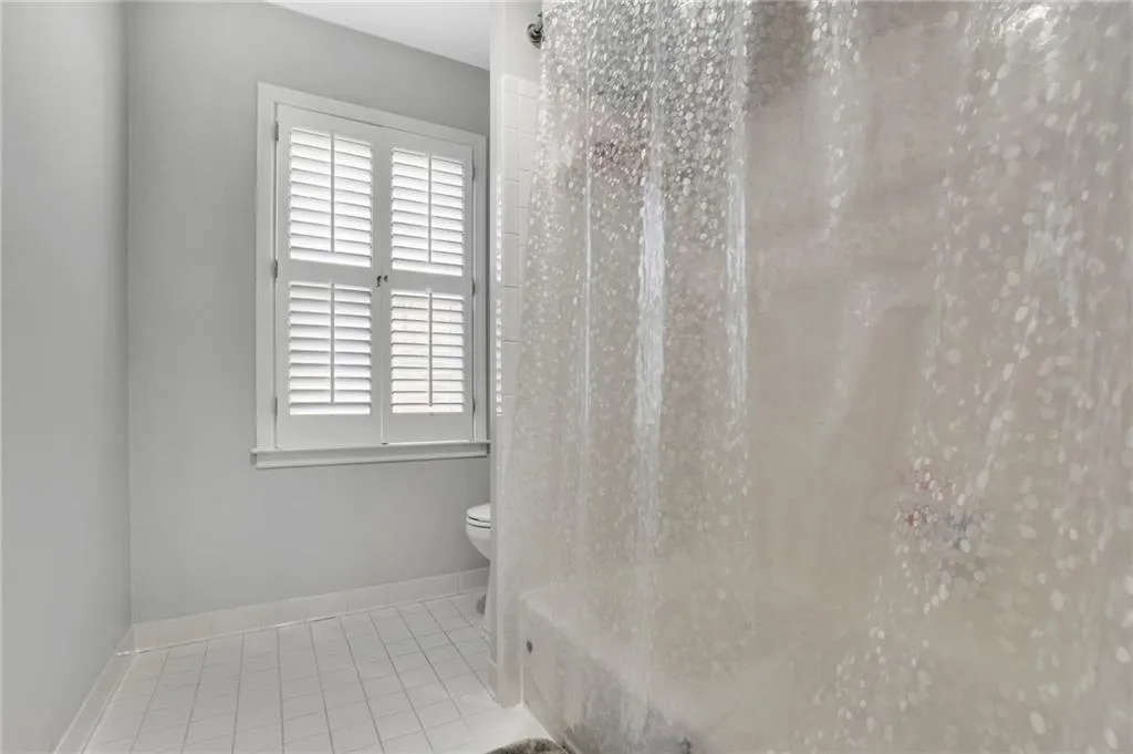 Full bathroom featuring toilet and light tile patterned floors
