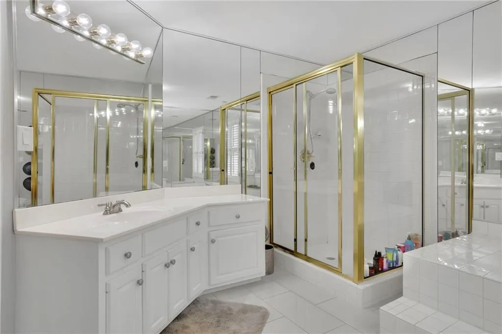 Full bathroom featuring vanity, light tile patterned floors, and a stall shower