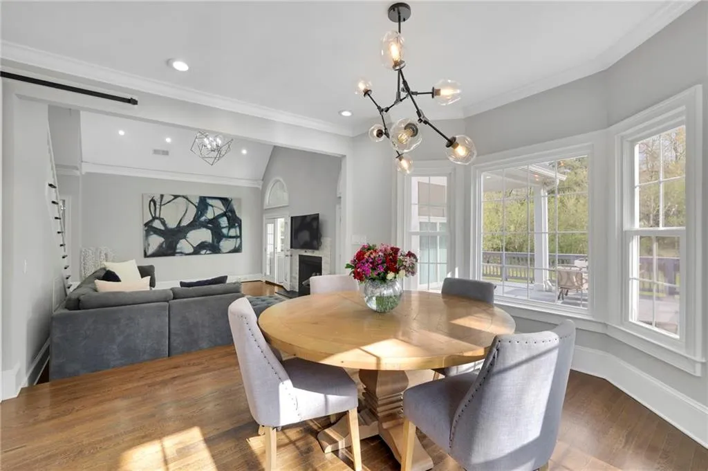 Dining room featuring hanging lights, lofted ceiling, ornamental molding, and wood finished floors