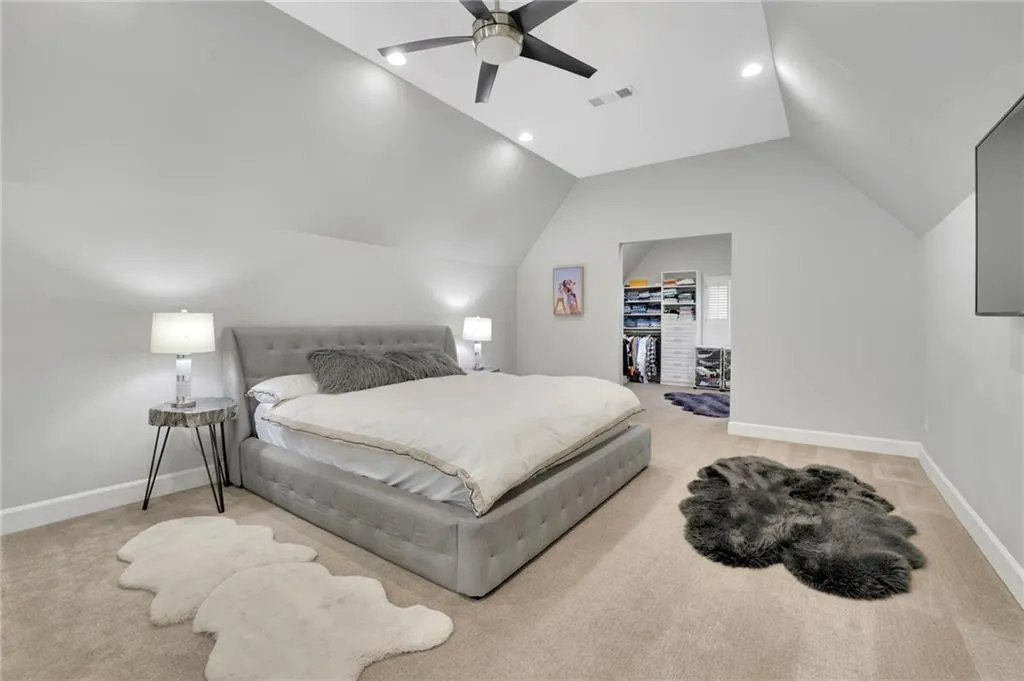 Bedroom with light carpet, a spacious closet, a ceiling fan, and recessed lighting