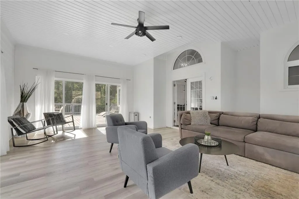 Living area with light wood-type flooring, a ceiling fan, and wood ceiling
