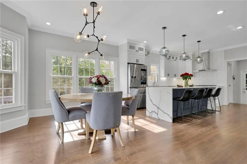 Dining room featuring crown molding, dark wood-style floors, and a chandelier