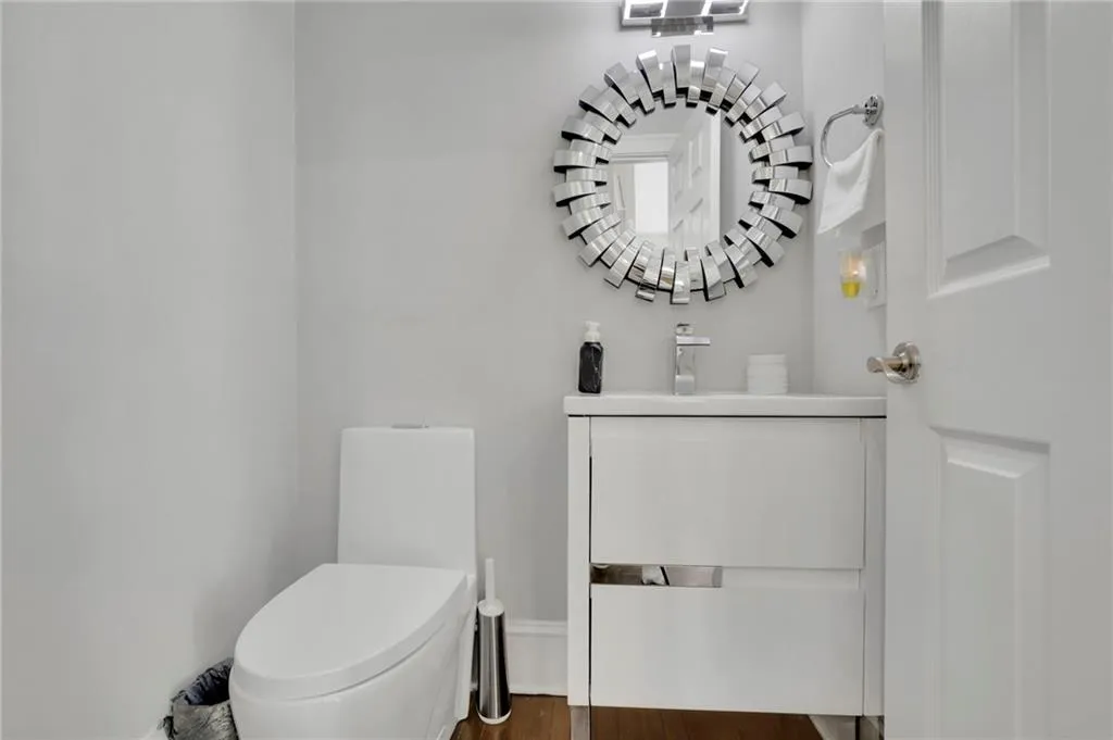 Half bathroom featuring vanity and dark wood-type flooring