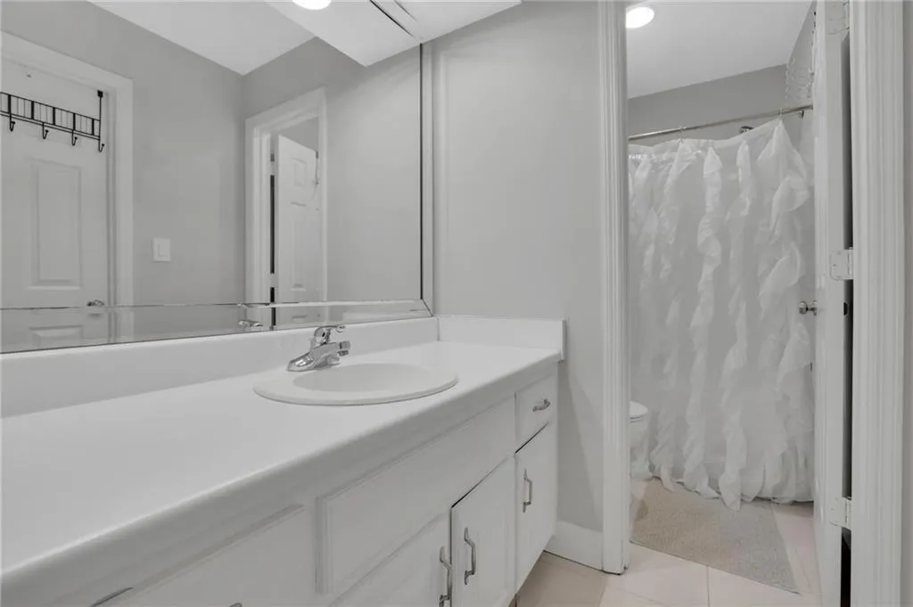 Full bathroom featuring vanity, a shower with shower curtain, and light tile patterned floors