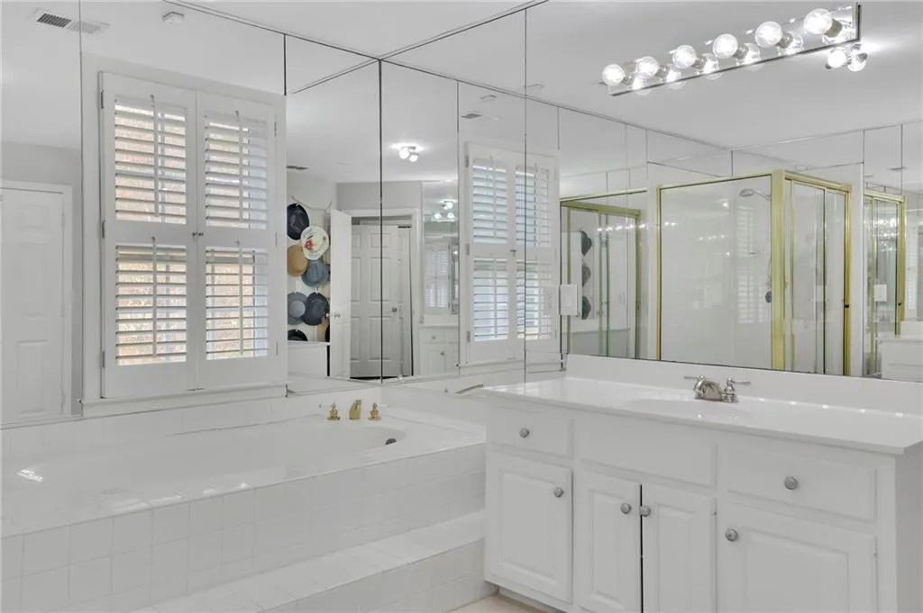 Bathroom with vanity, healthy amount of natural light, a bath, and a shower stall