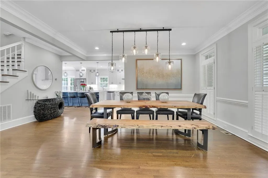 Dining area with wood finished floors, ornamental molding, and recessed lighting